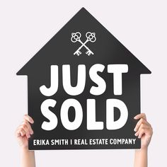 someone holding up a sign that says just sold in front of a house with keys on it