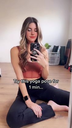 a woman sitting on the floor taking a selfie with her cell phone and text that reads, try this yoga pose for 1 minn