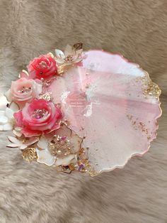 a pink and white flower arrangement sitting on top of a fur covered floor