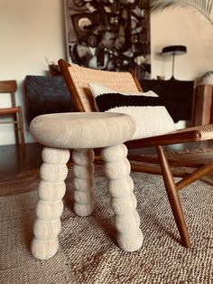 a wooden chair sitting on top of a rug in a living room