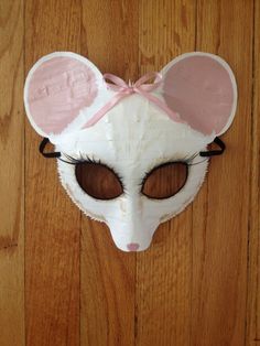 a white mask with pink ears on top of a wooden floor