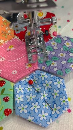 the sewing machine is next to several colorful hexagons with flowers on them