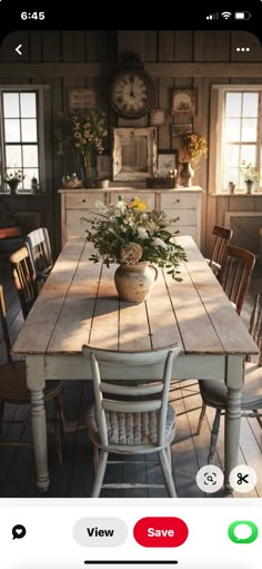 an image of a dining room table with flowers in the center and chairs around it