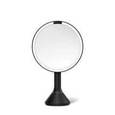 a black stand with a round mirror on it