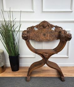 an old wooden chair sitting next to a potted plant