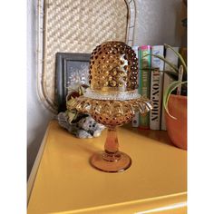 a yellow table topped with a cake covered in gold filigreets and surrounded by books