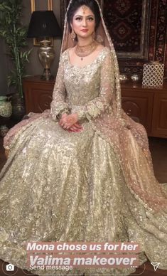 a woman in a gold gown sitting on a chair with her hand on her hip