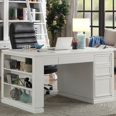 a white desk with a laptop on it in front of a bookcase and window