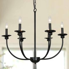 a black chandelier with five lights hanging from it's center rod and four arms