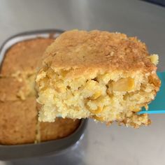 a close up of a piece of cake in a pan with a blue spatula