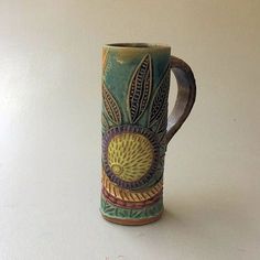 a ceramic coffee cup sitting on top of a white table