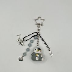 a keychain with a penguin and star charms attached to it's side