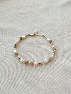 "Please review the bracelet sizing guide below for the perfect fit! This mixed gemstone and pearl beaded bracelet makes a lovely addition to your bracelet stack! The genuine moonstone, sunstone, peridot, and pink pearls are accented by creamy white pearls. Each bracelet is hand beaded to order 🫶🏻 * 2-9mm mixed natural Gemstones and Pearls * 14K Gold Filled or 925 Sterling Silver accents * 14/20 GF 925 stamp for authenticity * Made with all hypoallergenic materials 🤍 * Choose your length. Each bracelet comes with a 1\" extender chain for adjustable sizing. Bracelet Sizing Guide: 5-6.5 inches = xtra small 6.5-7 inches = small 7-8 inches = medium 8 inches+ = large Each Bracelet is measured held taught from tip to end. Unsure what size to choose? The best way to find the right size is to ta Thick Beaded Bracelets, Neutral Beaded Bracelets, Dainty Pearl Bracelet, Stone Beaded Bracelets, Beaded Bracelet Stack, Pearl Beaded Bracelet, Multicolor Bracelet, Peridot Bracelet, Pearls Bracelet