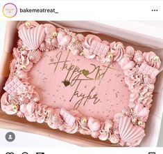 a pink birthday cake in a box on a table