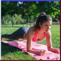 a woman doing push ups on a pink mat in the grass with trees behind her