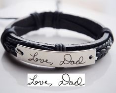 a leather bracelet with the words love, dad engraved on it