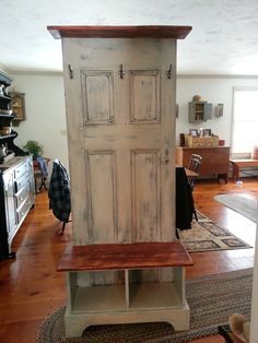 an old door is sitting on top of a bench in the middle of a living room