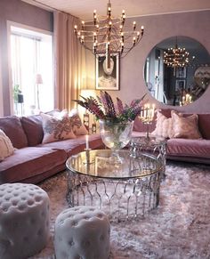 a living room filled with lots of furniture and a chandelier above the coffee table