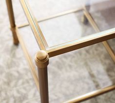 a glass top table with wooden legs on carpeted floor