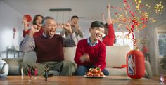 an older man and young boy sitting on a couch with their hands up in the air