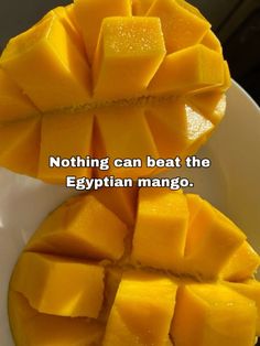 a white bowl filled with sliced mangos on top of a wooden table next to a quote that reads nothing can beat the egyptian mango