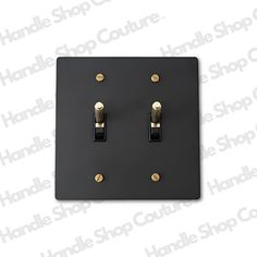 a black and gold light switch plate with two lights on each side, in front of a white background