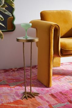 a yellow chair sitting next to a table on top of a pink carpeted floor