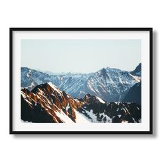 the mountains are covered in snow and there is a black frame hanging on the wall