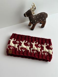 "Stylish Reindeer theme Women's Winter headband in beautiful holiday inspired colors! This hand dyed fiber has a beautiful tone of red, leaning to almost a burgundy's red for the background color. A beautiful neutral color of cream, named Natural, is gently stitched in, to resemble little deer with horns!  This fun fair isle knit headband will get you thru chilly mornings all while looking fashionably cute! Great staple from fall through the spring when you just don't want to wear a full hat!  Made with ultra soft 100% superwash merino wool  in a 4 weight class, so just a nice all around not too heavy weight and NO scratchiness. Headband is trimmed with a little vegan reindeer tag, hand sewn on! This headband /ear warmer is made to fit average size of 20.5\"-22\" circumference head.  Styli Christmas Knitted Headband, Crochet Christmas Ear Warmers, Knitted Winter Headbands, Reindeer Crochet Headband, Adjustable Red Winter Headband, Deer Headband, Winter Headband, Winter Apparel, Winter Headbands