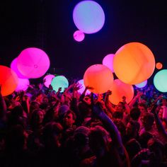 a large group of people with balloons in the air