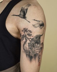 a man with a tattoo on his arm has a tiger and other animals in the background