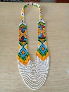 a multicolored beaded necklace is displayed on a table