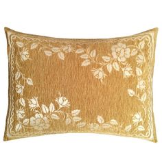 a gold and white pillow with flowers on it