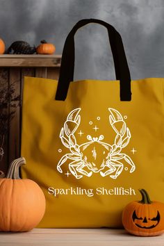 a yellow shopping bag sitting on top of a table next to pumpkins and other decorations