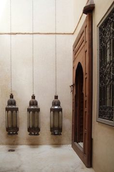 three hanging lanterns in front of a doorway