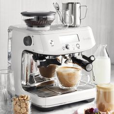 an espresso machine sitting on top of a counter next to other coffee items