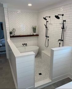 a bathroom with white tile and black fixtures in the bathtub, shower head, and toilet