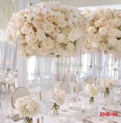 there are many tall vases with flowers in them on the table at this wedding reception