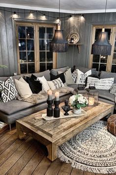 a living room filled with lots of furniture and pillows on top of a wooden floor