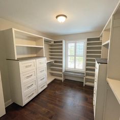 an empty room with lots of shelves and drawers in the corner, along with a window