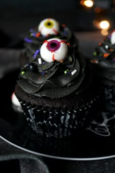 cupcakes decorated with black icing and spooky eyes