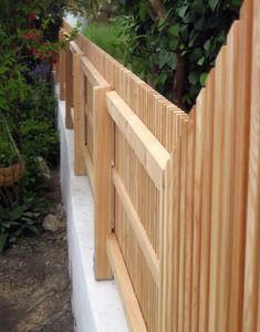 a wooden fence that is next to some plants