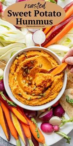 roasted sweet potato hummus in a white bowl with carrots and radishes