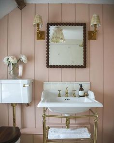 a white sink sitting under a mirror in a bathroom