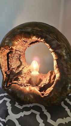 a candle is lit in the middle of a piece of wood that has been carved into it