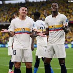 two soccer players are standing on the field with their hands in each other's pockets