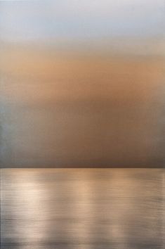 an abstract painting with gold and silver colors on the water's surface, as seen from across the ocean