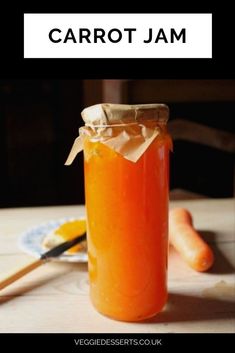 a jar filled with orange liquid sitting on top of a table next to a plate