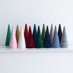 a row of colorful cones sitting on top of a white shelf