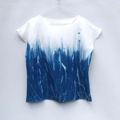 a blue and white t - shirt hanging on a hanger